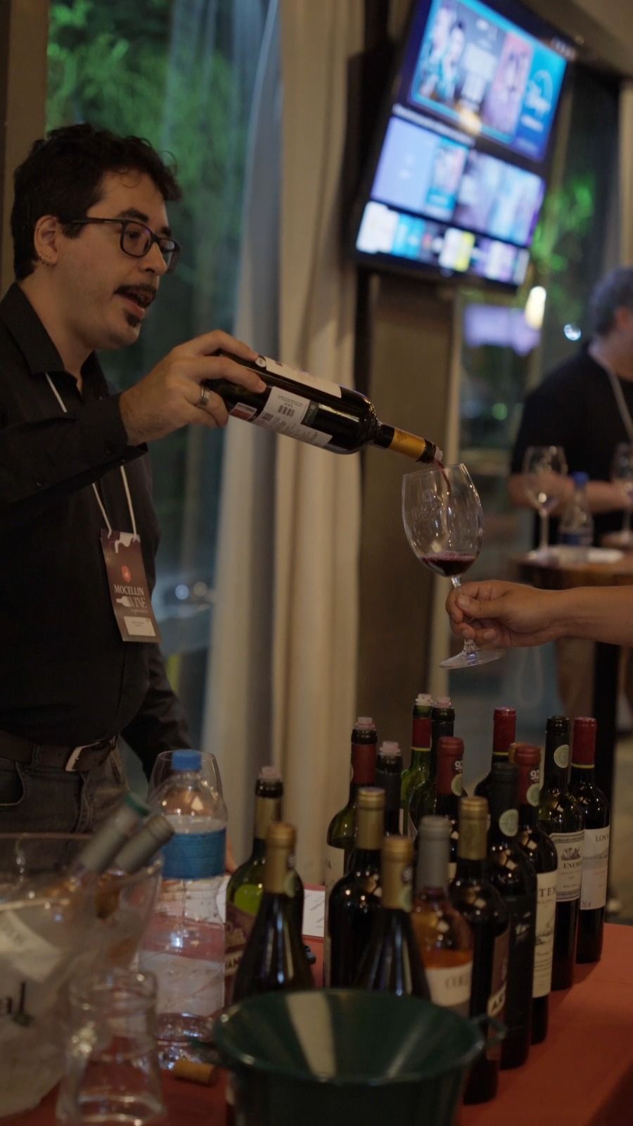 Vinho sendo servido na taça de um convidado durante o evento